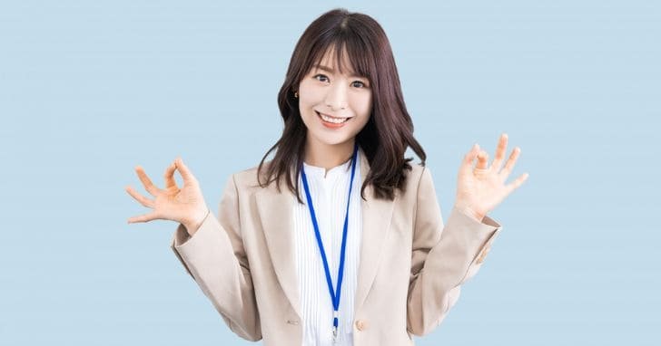 両手でOKマークのジェスチャーをしている女性